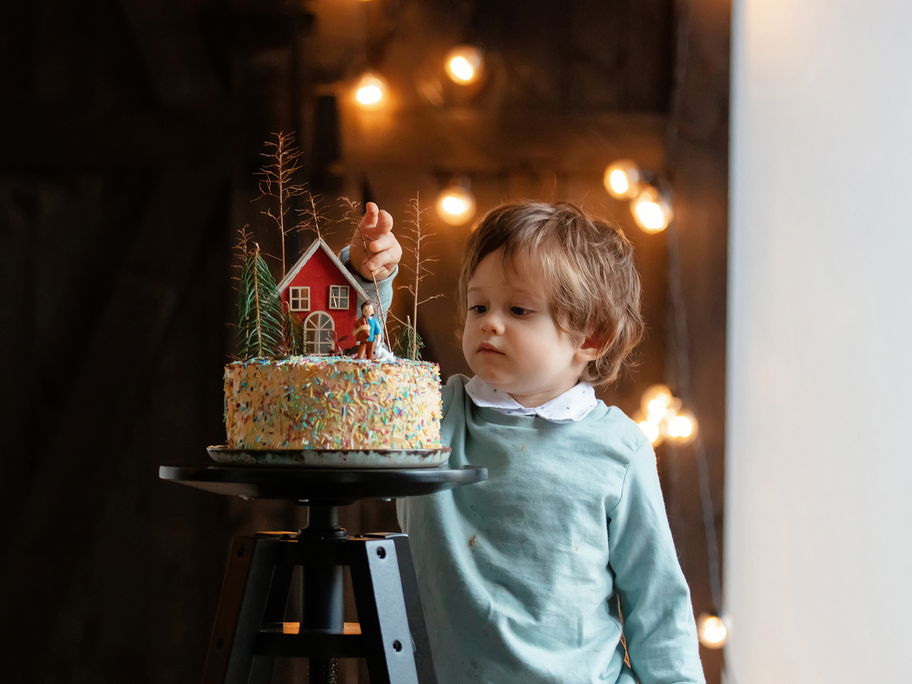 Ein kleiner Junge steht vor einer Torte.