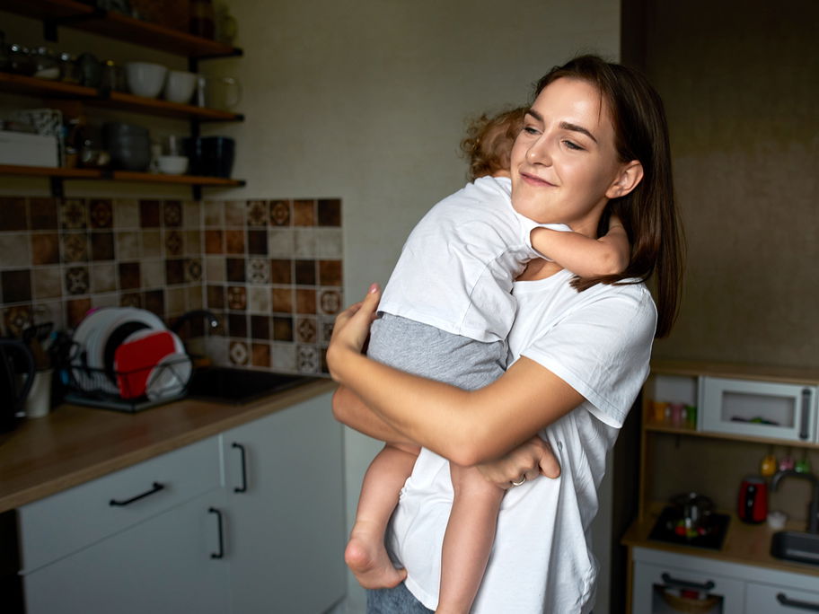 Mama und Kleinkind umarmen sich.