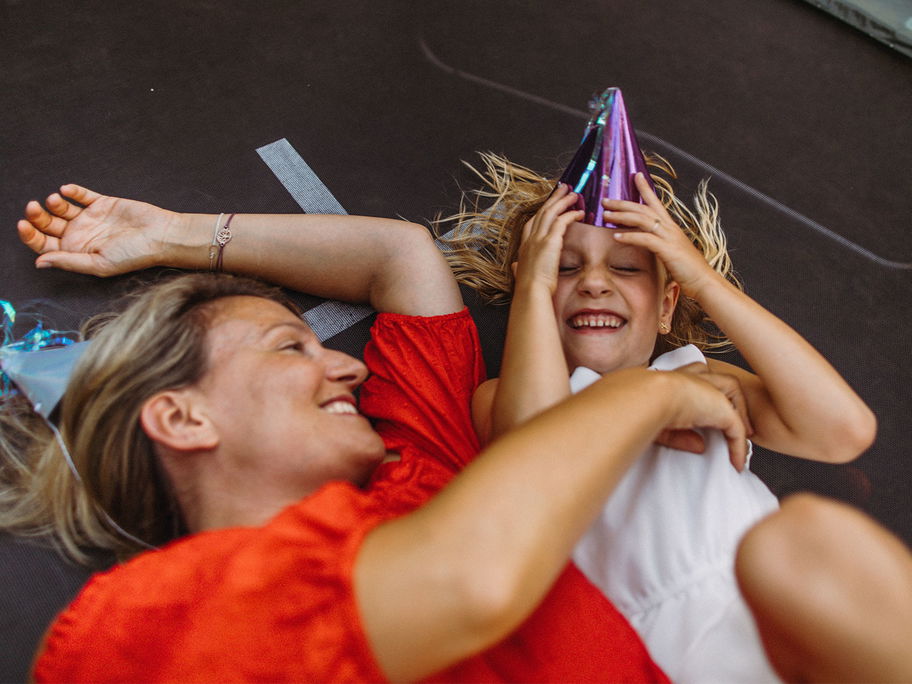 Mutter und Kind liegen auf Trampolin.