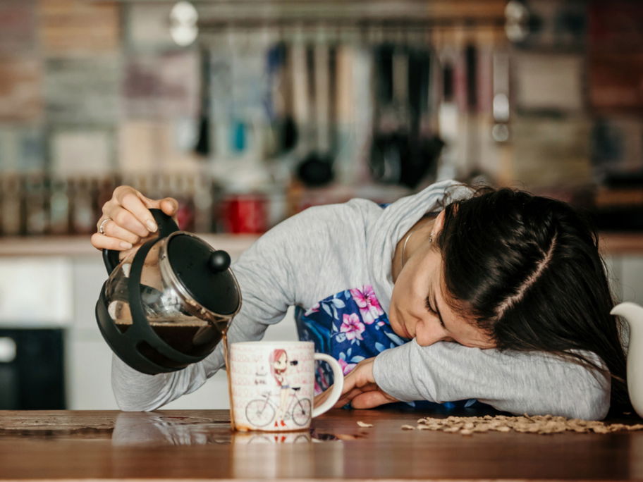 Müde Mama verschüttet Kaffee.