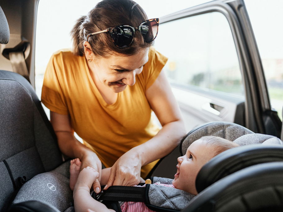 Eine Mutter schnallt ihr Baby im Auto an.
