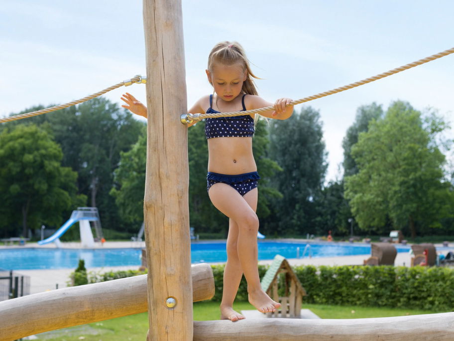 Mädchen balanciert im Schwimmbad.