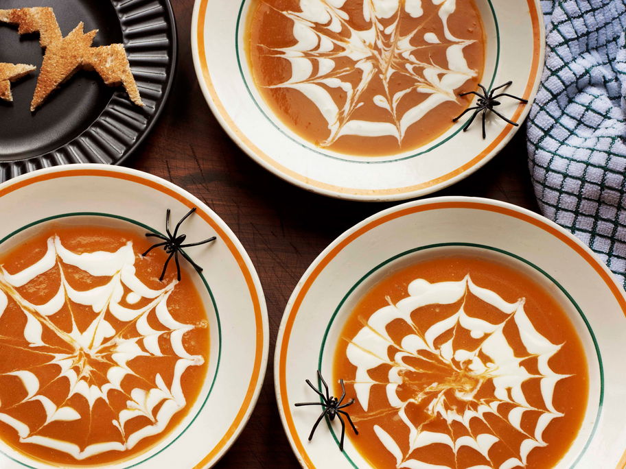 Halloween-Kürbissuppe mit Spinnennetzmuster.