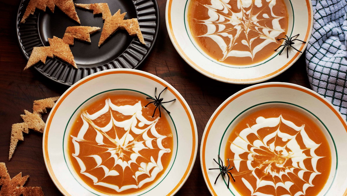 Halloween-Kürbissuppe mit Spinnennetzmuster.