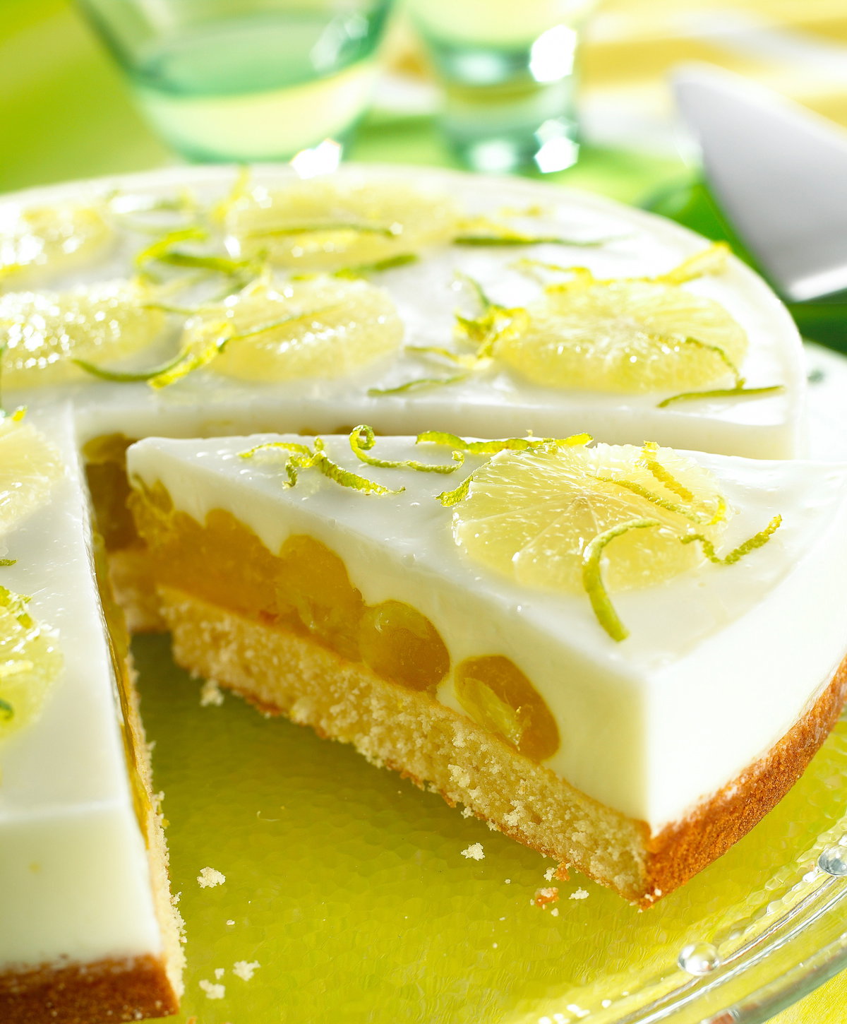 Eine runde Fantatorte mit Limette liegt auf einer Kuchenplatte.
