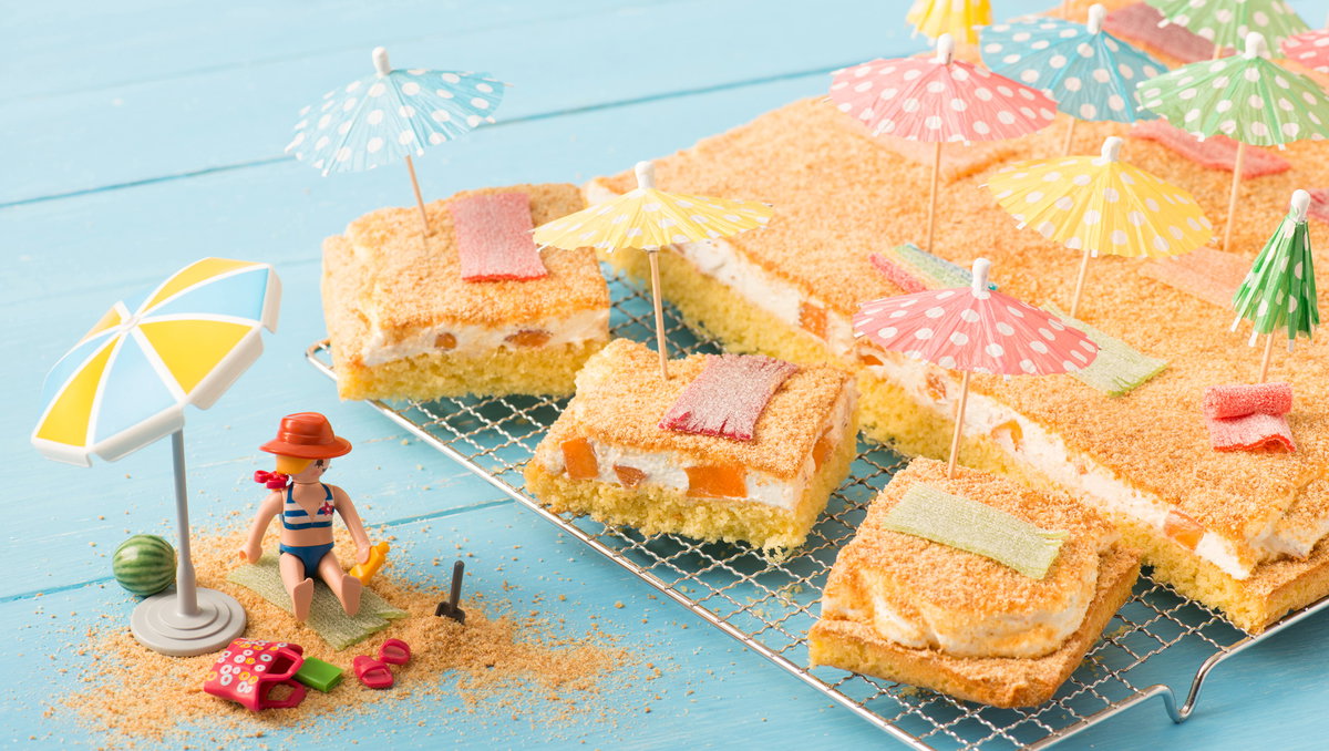 Ein sommerlicher Fantakuchen ist mit Deko-Schirmchen dekoriert.