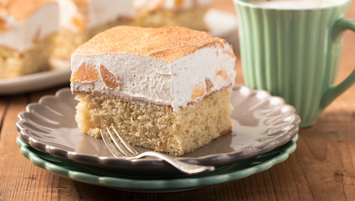Ein Stück Fantakuchen mit Schmand liegt auf einem Teller.