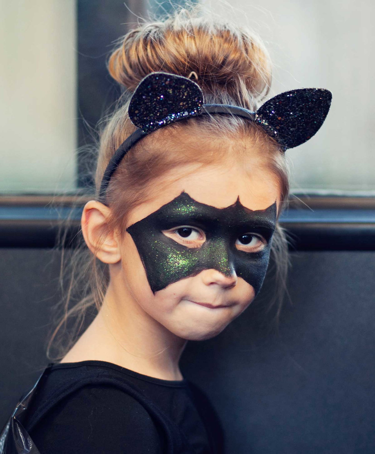 Mädchen als Fledermaus geschminkt.