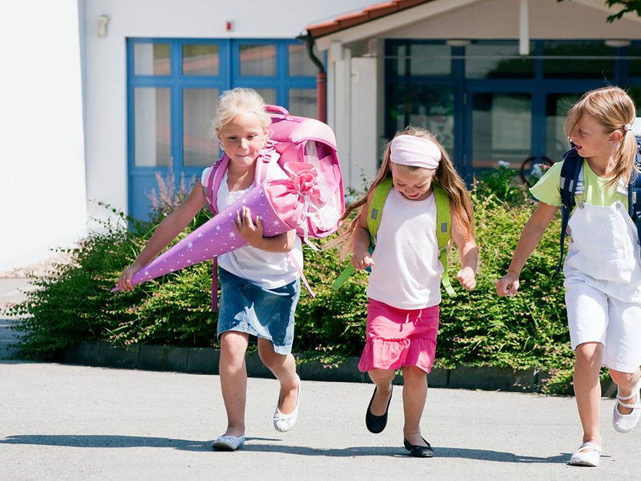 Drei Schulkinder mit einer Schultüte.