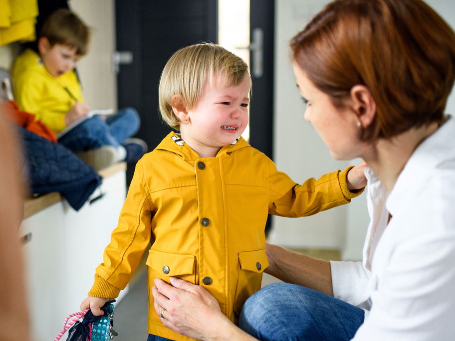 Ein Geschwisterkind kommt weinend zur Mama.