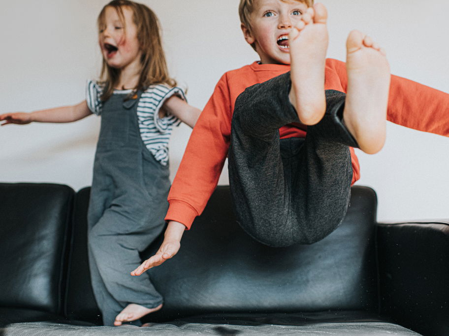 Zwei auf dem Sofa tobende Kinder