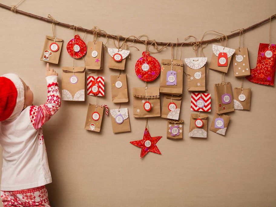 Kleines Kind mit selbst gemachtem Adventskalender.