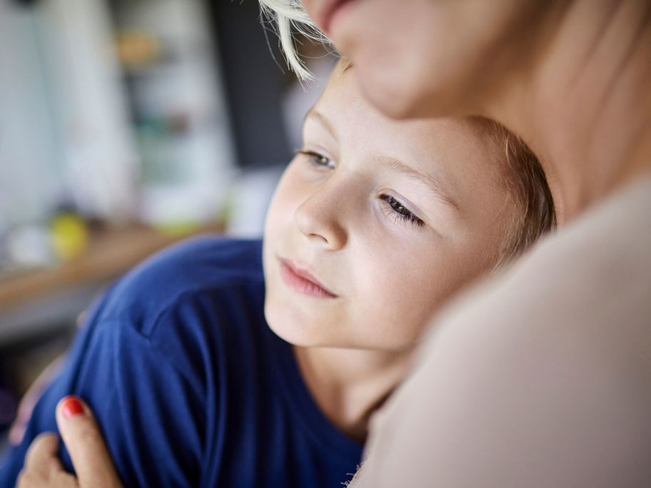 Ernster Sohn kuschelt mit Mutter.