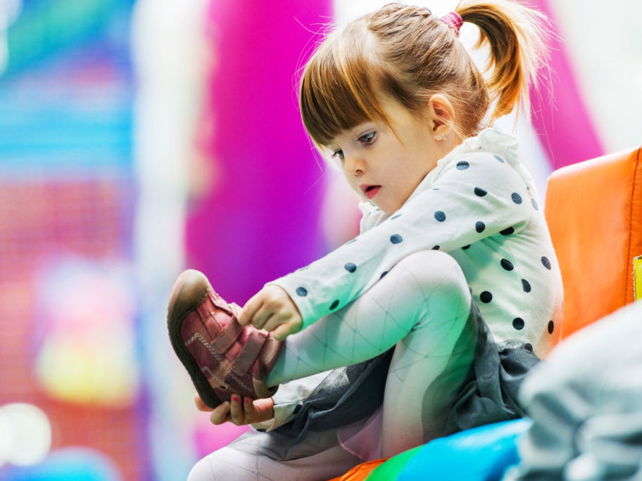 Das Anziehen der Schuhe ist für Kinder anfangs gar nicht so leicht.