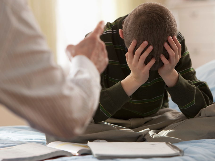 Vater schimpft mit Sohn im Schulalter