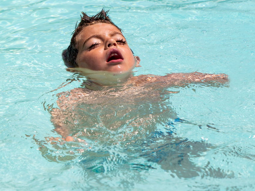 Junge mit geschlossenen Augen im Wasser.