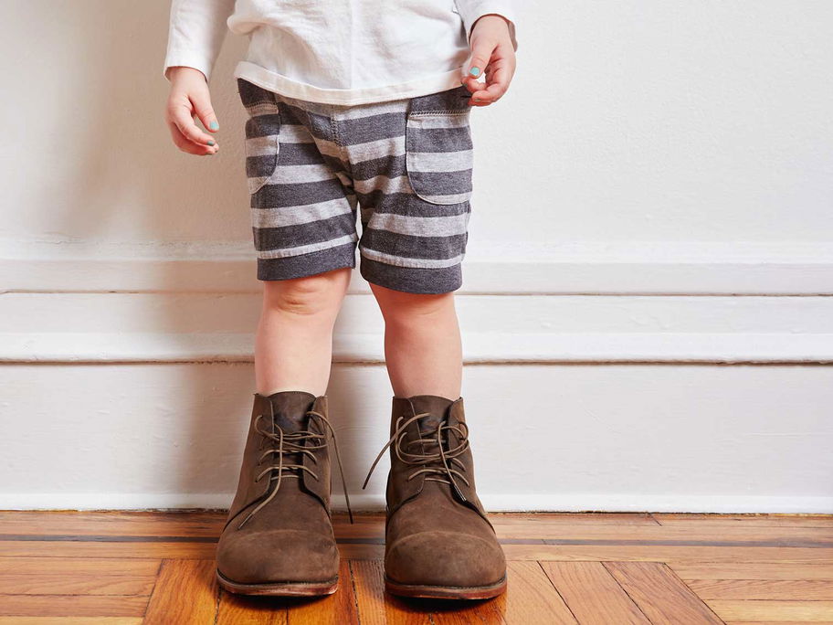 Kleinkind mit viel zu großen Schuhen.