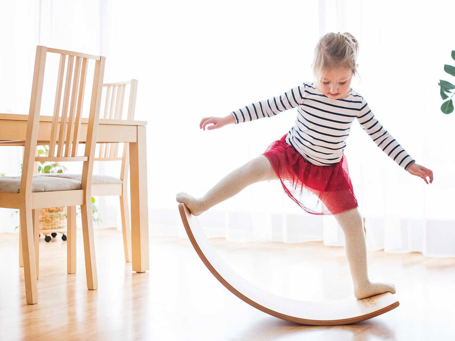 Ab wann Balance Boards geeignet sind? Auf jeden Fall schon für kleine Kinder! Optimalerweise sollten sie – anders als die geübte Turnerin hier – barfuß aufs Board.