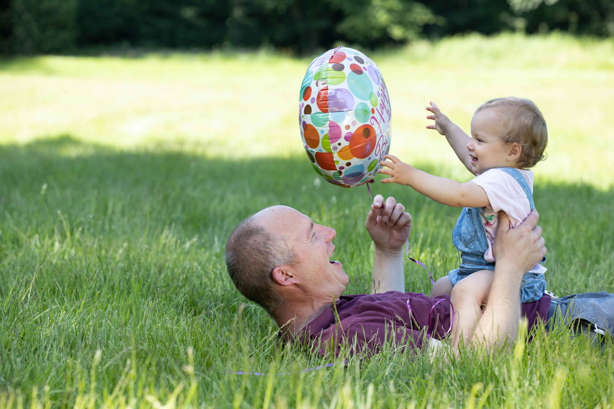 Vater und Kleinkind mit Luftballon.