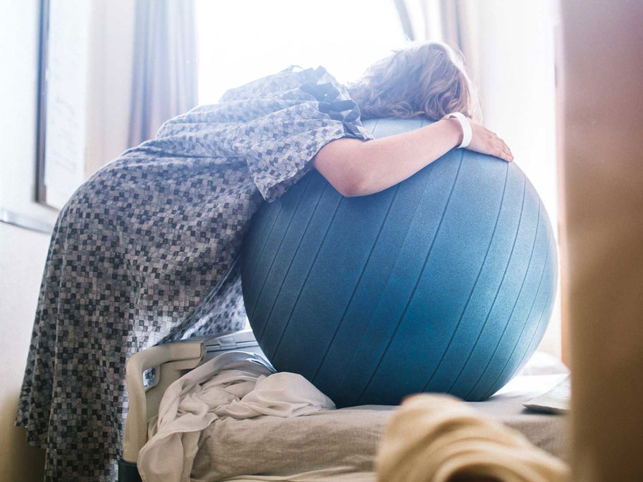 Ein Gymnastikball kann bei der Geburt unterstützen.