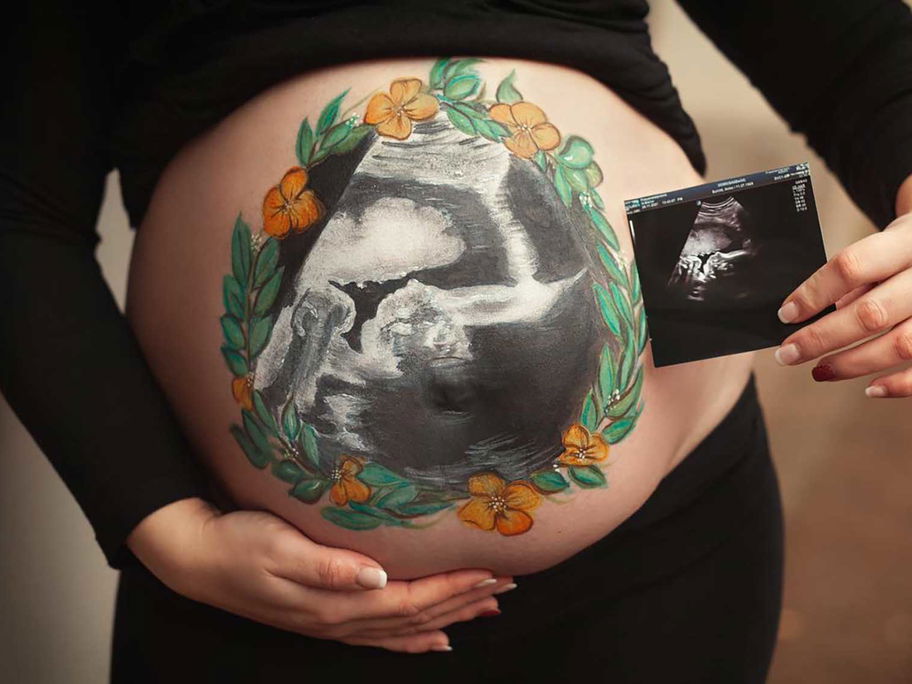 Ein Babybauch mit dem eigenen Ultraschallbild bemalt. Was für eine besondere Erinnerung an die Schwangerschaft.