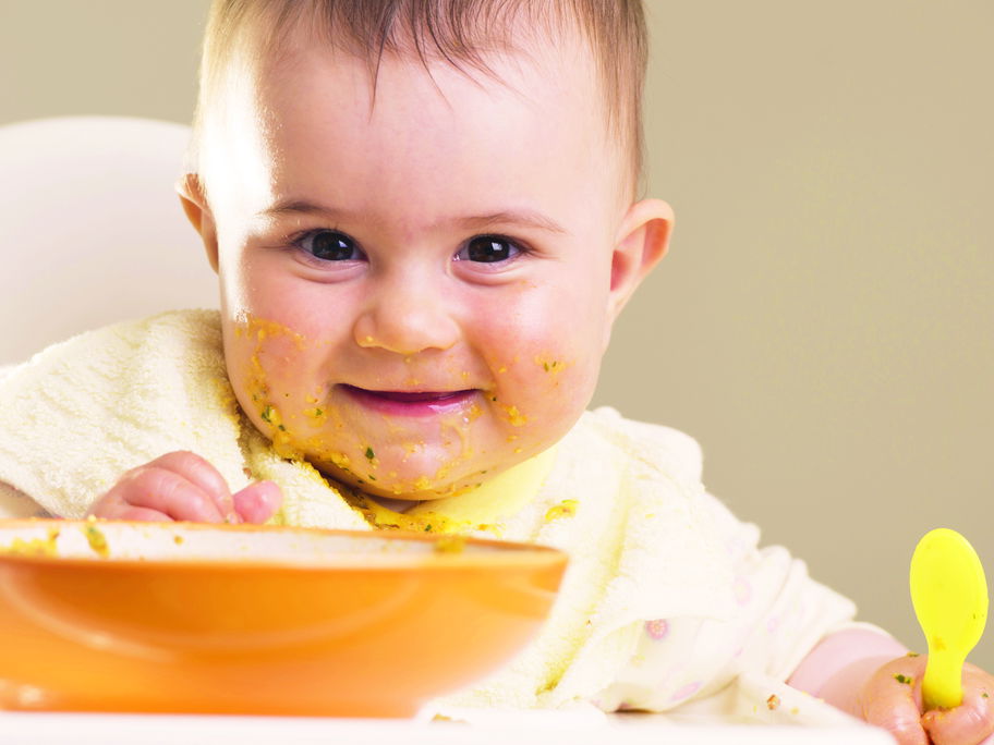 Baby mit breiverschmiertem Mund.