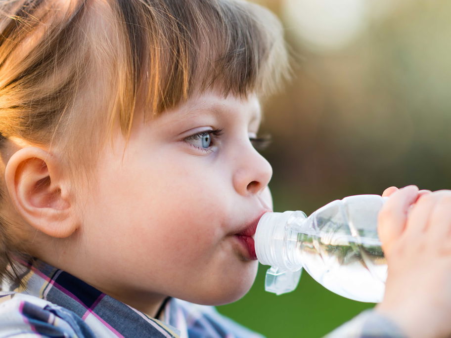 Mädchen trinkt aus einer Wasserflasche.